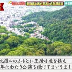 Aerial view of a forested hillside with a town at the base; handwritten caption in Japanese describes building a theater at the foot of Mount Kanpiray and continuing performances for 45 years.