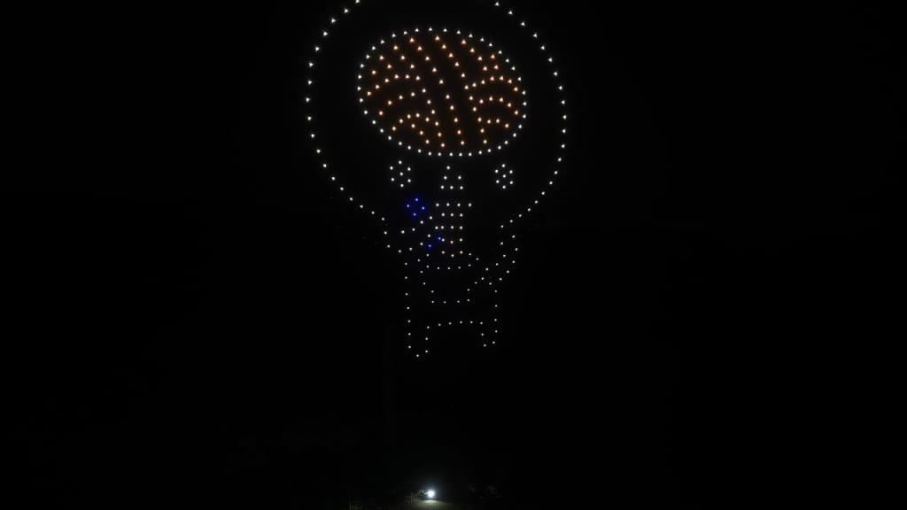 Skull-shaped LED art installation at night, with orange brain area and white dots outlining the skull.